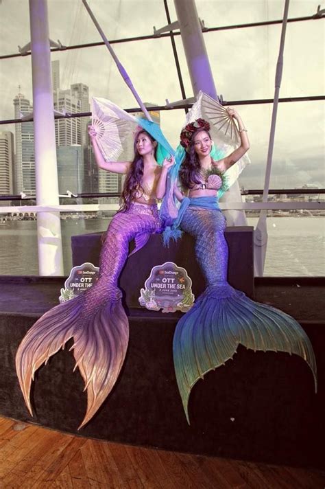 Mermaids At Play While The City Of Singapore Dazzles In The Background