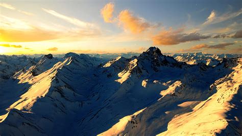 Snow Covered Mountain With Blue Sky And Clouds Background During Sunset