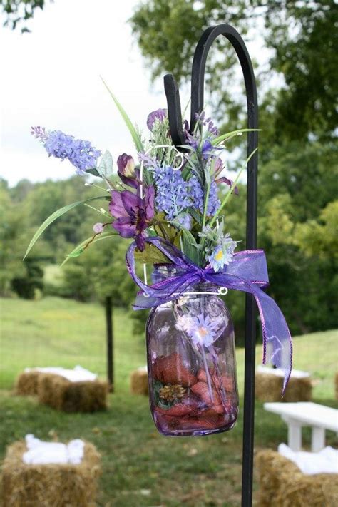Mason Jars Filled With Flowers Hanging From Shepherd Hooks Marking Isle