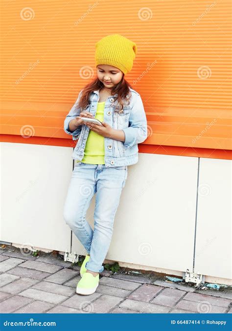 Fashion Little Girl Child Wearing A Jeans Clothes Using Smartphone Over