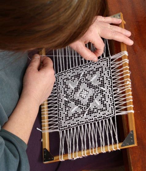 A Woman Is Working On An Intricate Piece Of Art With White Thread And