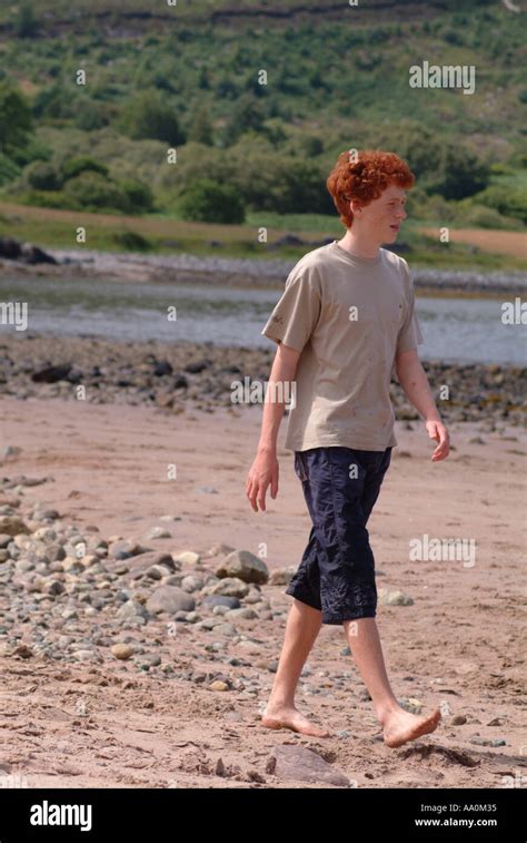 Teenage Boy Walking Alone On A Beach Stock Photo Alamy