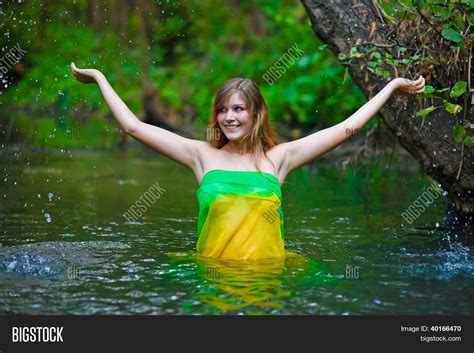 weibliche Frau nackt Modell stehen unter dem Regen Taille tief im Wasser auf einem grÃ¼nen