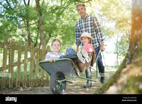Daddy Riding Kids In Wheelbarrow Stock Photo Alamy