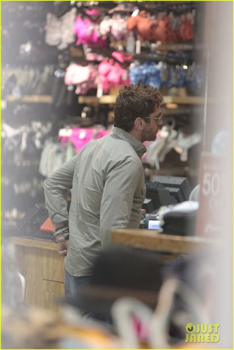 gerard butler scopes out surf gear after kissing session with mystery