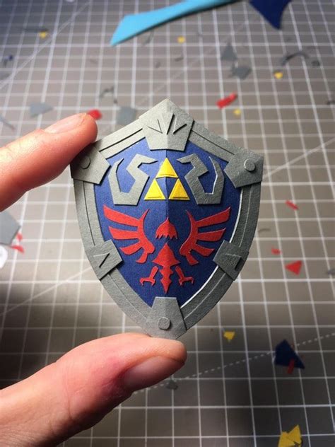 Someone Is Holding Up A Paper Model Of The Legend Of Zelda Shield With