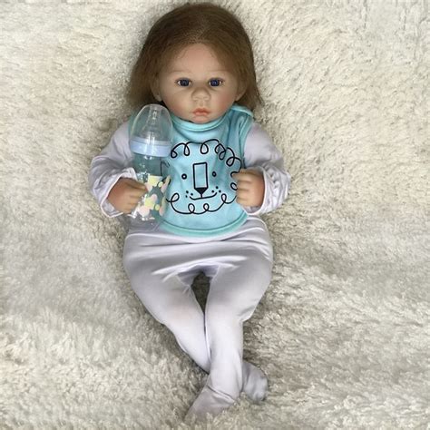 A Baby Doll That Is Laying Down With A Bottle In Its Hand And Wearing