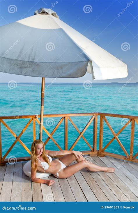 The Female Body Sunbathes On A Beach Against The Sea Stock Image