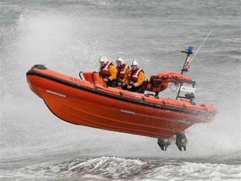 An Orange Boat In The Water With People On It