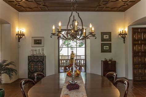 A Dining Room Table With Chairs And A Chandelier Hanging From The