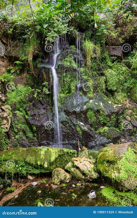 Vertical Shot Of A Beautiful Powerful Waterfall Flowing Through Rocks