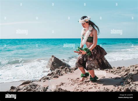 A Caucasian Female Dancing Hawaiian Hula Dance On The Beach Against The