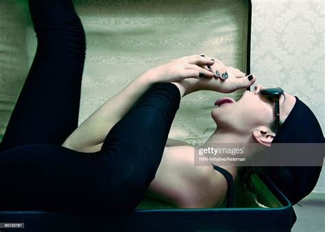 Side Profile Of A Young Woman Lying In A Suitcase And Licking Her Foot Argentina High Res Stock