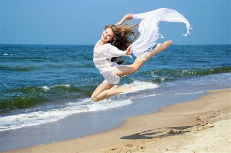 Chica Joven Feliz Que Salta En La Playa Foto De Archivo Imagen De