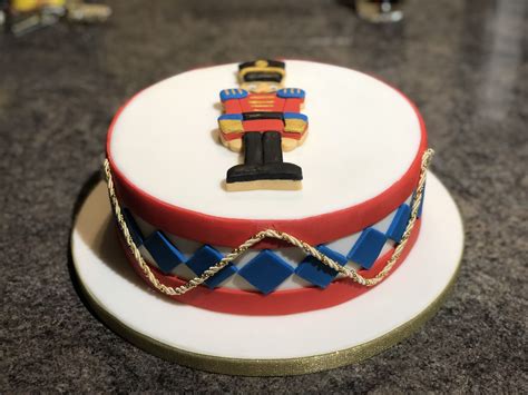 A Decorated Cake On A White Plate With Blue And Red Ribbon Around The