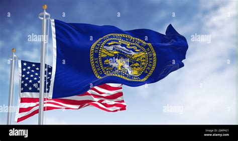 The Nebraska State Flag Waving Along With The National Flag Of The