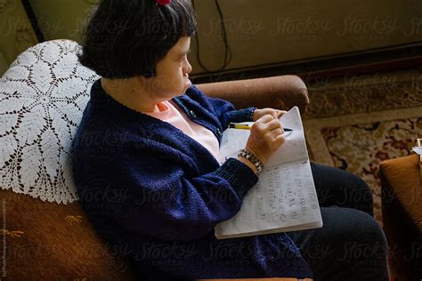 Woman With Down S Syndrome Writing In Her Notebook Del Colaborador De Stocksy Branislava