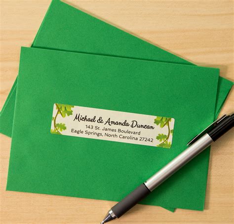 Two Green Envelopes And A Pen On A Wooden Table With A Label That Says