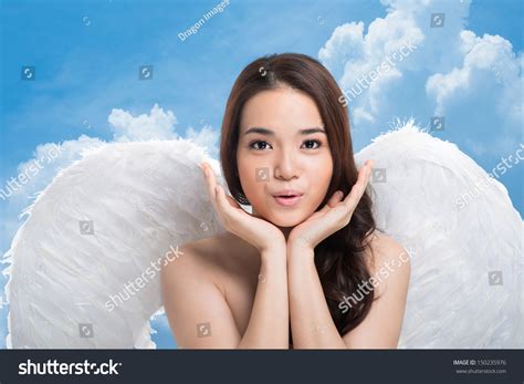 Portrait Of An Angel With Beautiful Face Posing Against Sky Background