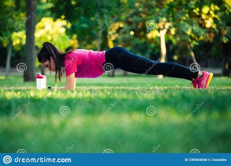 Fit Girl Doing Plank Exercise Outdoor In The Park Warm Summer Day