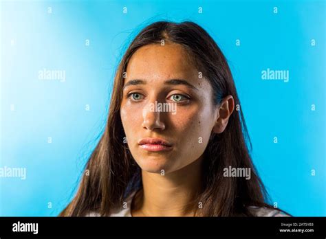 Beauty Shot Of Tanned Skinned Woman On Blue Background Close Up