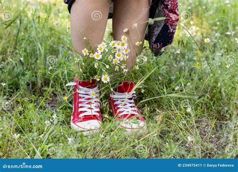 Upturned Skirt And Naked Legs In Red Sneakers With A Bouquet Of White