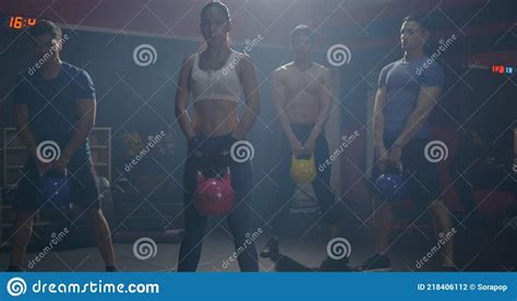 Muscular Group In Exercise Gear Standing In A Row Holding Dumbbells During An Exercise Class