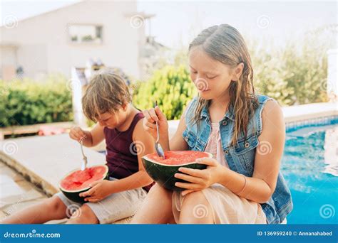 Outdoor Summer Portrait Of Two Funny Kids Eating Watermelon Stock Photo
