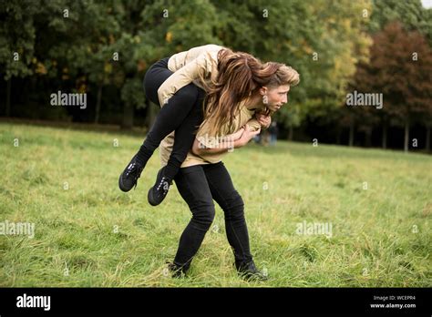 Young Man Carrying Woman On Shoulder At Park Stock Photo Alamy