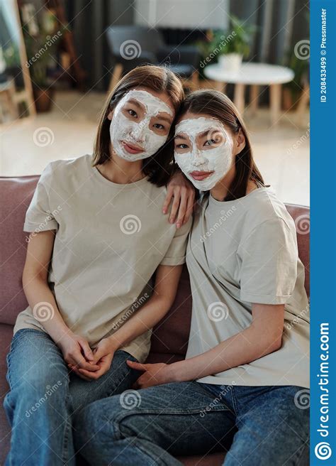 Zwei Junge Liebevolle Brunette Frauen Mit Lehmmaske Auf Den Gesichtern Die Sich Auf Die Couch