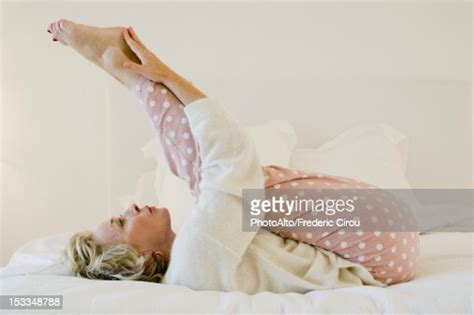 Mature Woman Lying On Bed Stretching Legs Photo Getty Images