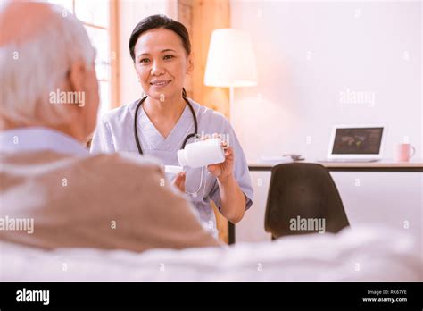 Positive Delighted Medical Worker Talking To Her Patient Stock Photo