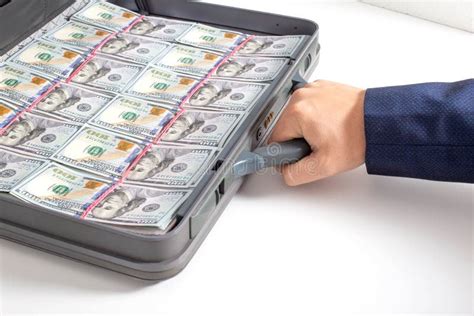 The Hand Of A Man Businessman Holds A Modern Briefcase With Money
