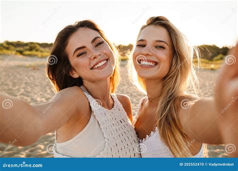 Deux Jeunes Femmes Caucasiennes Souriant Et Prenant Le Selfie Photo Sur La Plage Photo Stock