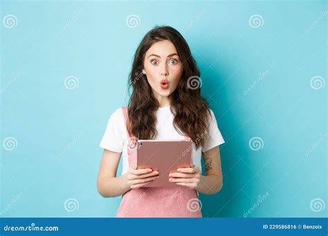 Impressed Cute Girl Say Wow Stare Excited At Camera Holding Digital Tablet Over Chest