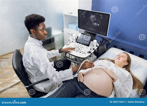 Young Pretty Pregnant Woman Getting Ultrasound Scan From Doctor Professional Confident African