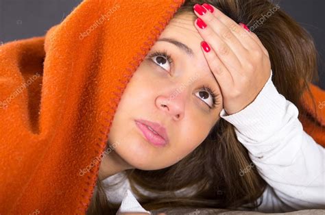Closeup Brunette Headshot Lying Down Under Orange Blanket And Blowing