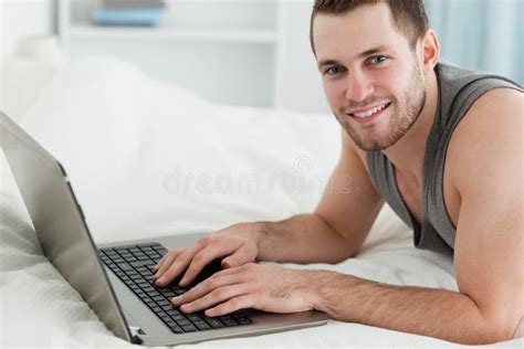 Handsome Man Using A Laptop While Lying On His Belly Stock Image