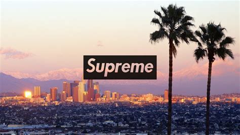 There Is A Sign That Says Supreme In Front Of Some Palm Trees And The City