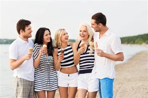 Amici Sorridenti Che Mangiano Il Gelato Sulla Spiaggia Immagine Stock Immagine Di Uscire
