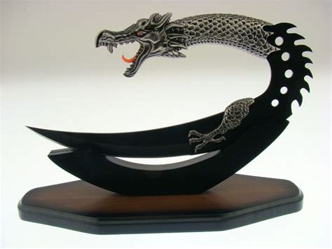 A Metal Dragon Sculpture Sitting On Top Of A Wooden Stand