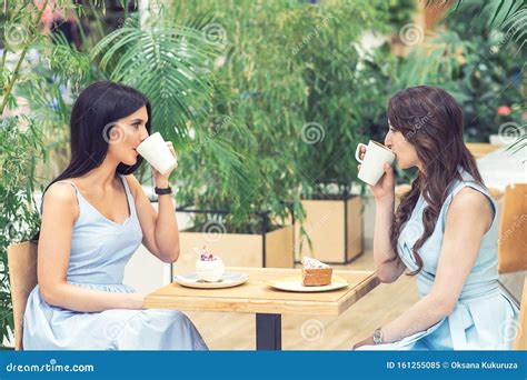 Two Young Women Are Drinking Coffee Together Outside Stock Image