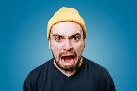 Close Up Young Mad Angry Displeased Guy In Yellow Cap Looking At Camera