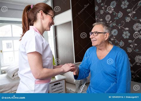 Careful Nurse Holding Hand Of Senior Patient And Comfort Him Stock