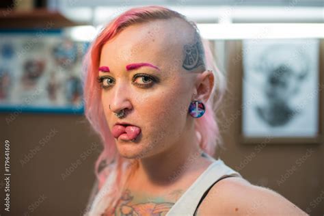 Zdjęcie Stock A Young Girl With A Shaved Head Pink Hair And A Tattoo