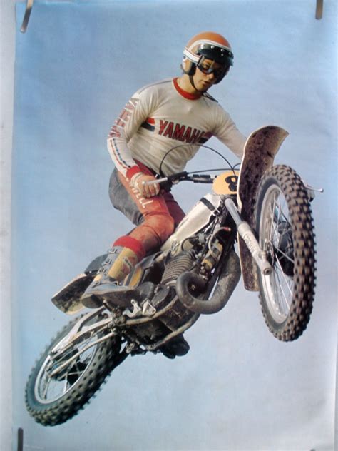 A Man Riding On The Back Of A Dirt Bike In Mid Air Over A Jump