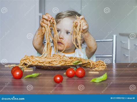 Funny Baby Child Getting Messy Eating Spaghetti With Tomato Sauce From