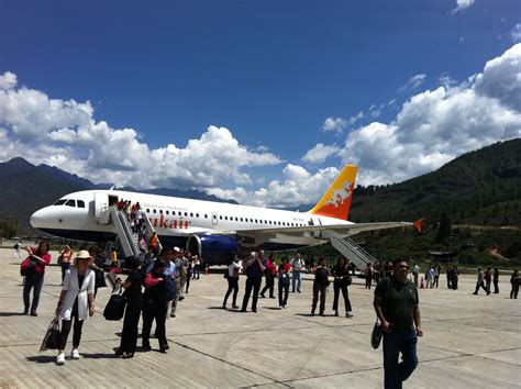 A Crowd Of People Standing On Top Of An Airport Tarmac Next To A Plane