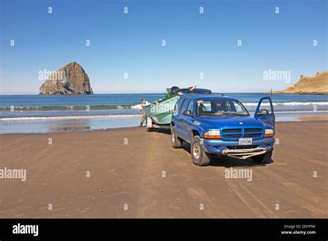 A Dory Fisherman Stands Near His Boat On The Beach At Pacific City