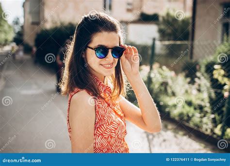 Stylish Hipster Woman Smiling In Sunglasses And Enjoying Sunshine In Sunny Street In Summer